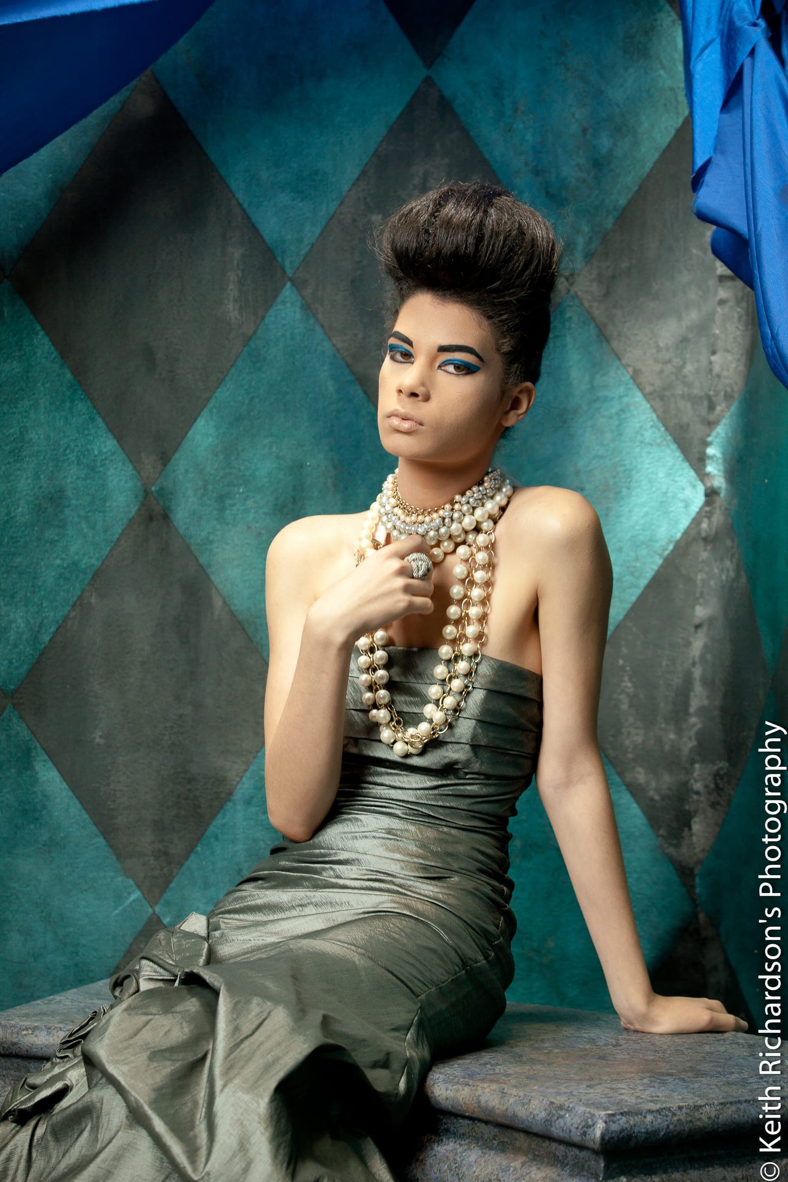 Editorial portrait draped in pearls on harlequin-tiled set